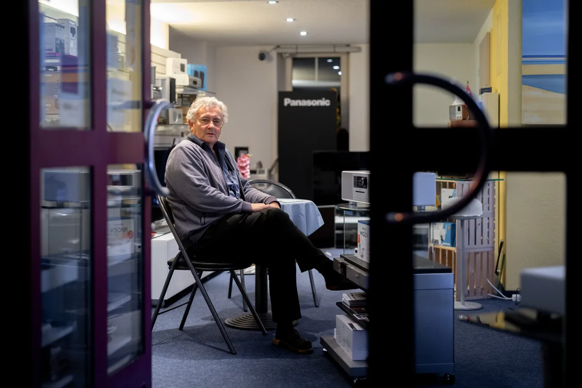 Max Masur, von aussen fotografiert, sitzt in seinem Showroom.